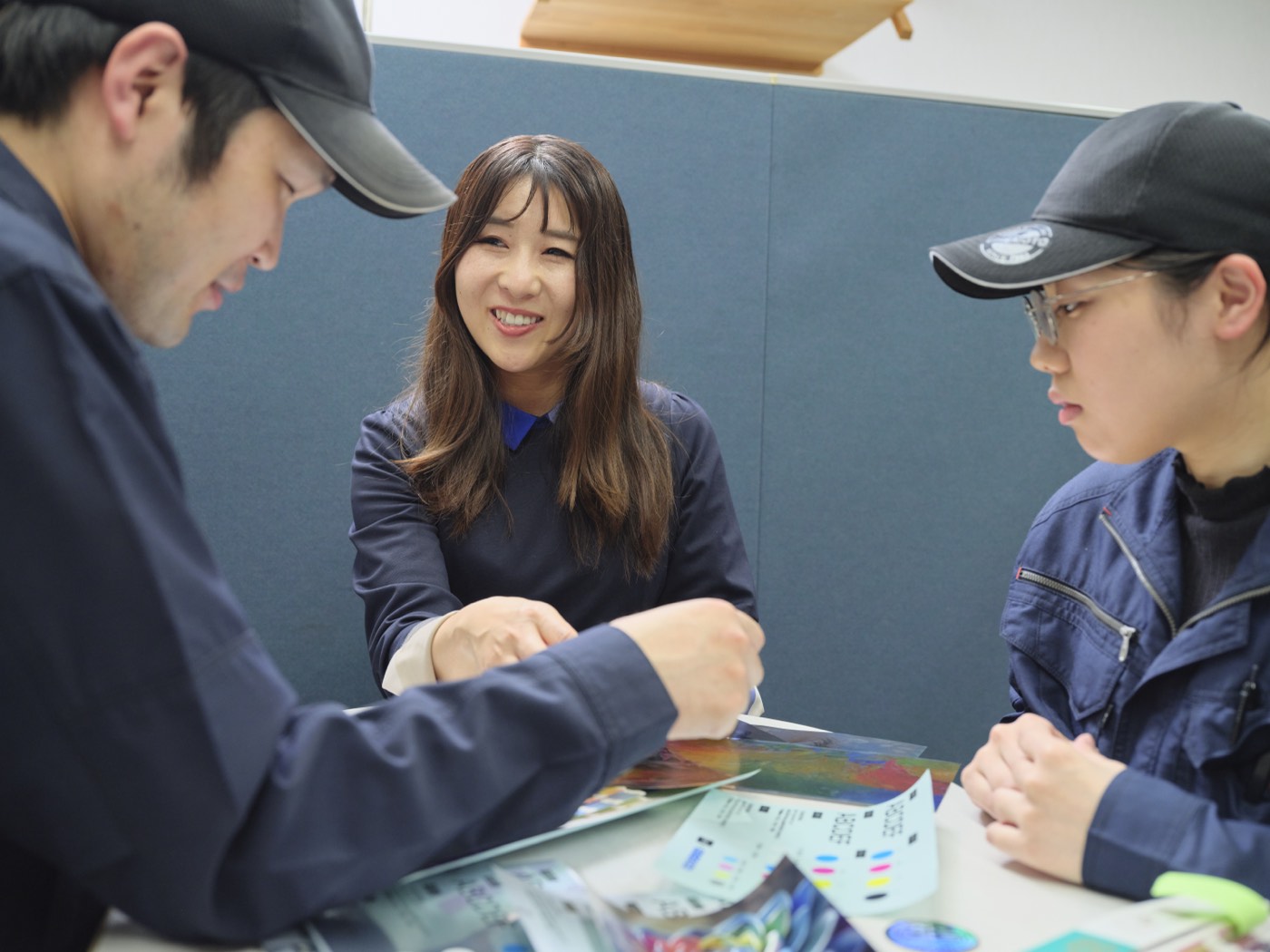 色見本を囲んで打ち合わせるウメモトのメンバーと関係者